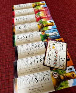 Eight cards with wine bottles on them in a line. Each wine bottle has a different order of numbers from 1 to 8. An additional client card with point values for types of wine or regions of wine sits on top two of the cards.